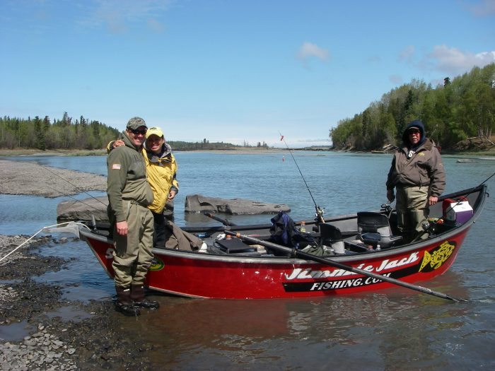 Three men in and around a fishing boat