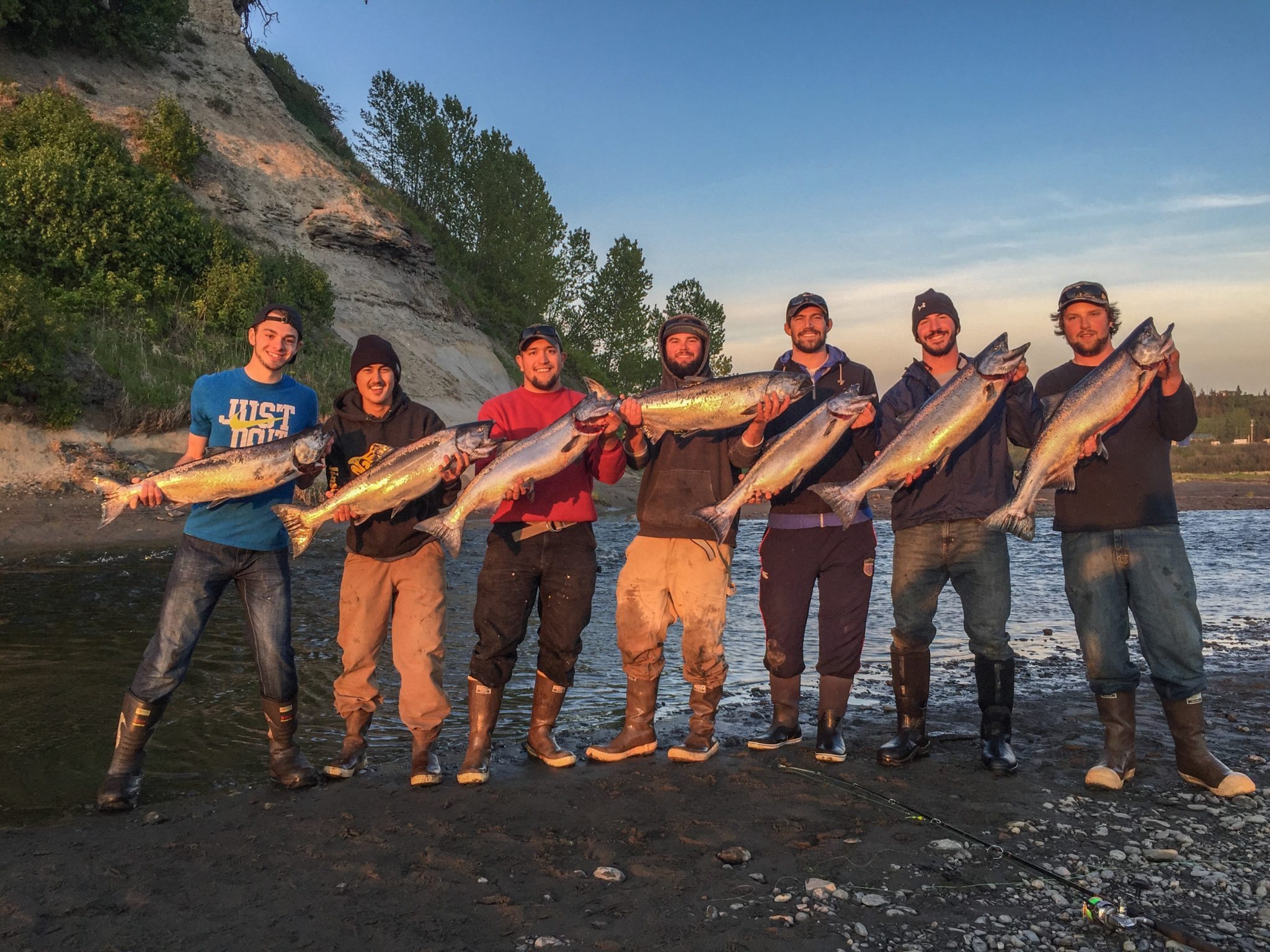 Group of men holding salmon