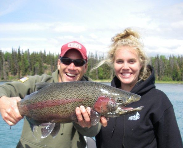 man and woman holding a rainbow salmon