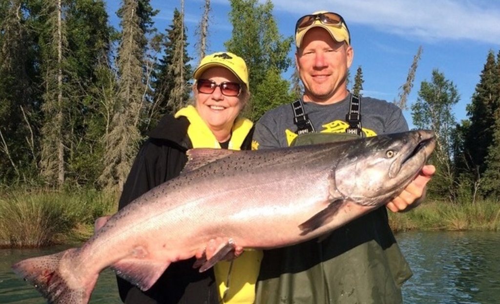 Guest and guide holding large salmon