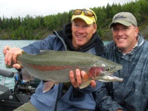A picture of Jimmie Jack holding up a trophy rainbow trout caught while fishing on the Kenai River.