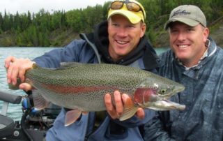 A picture of Jimmie Jack holding up a trophy rainbow trout caught while fishing on the Kenai River.