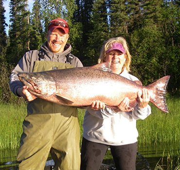 Jimmie and guest holding a large salmon