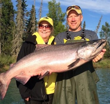 Jimmie and woman holding a large salmon