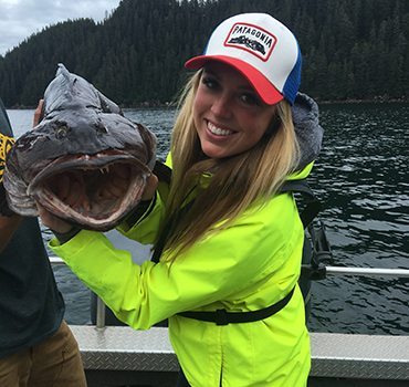 Woman holding a large lingcod fish