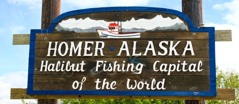 Homer Alaska sign. Text: Homer Alaska, Halibut Fishing Capital of the World.