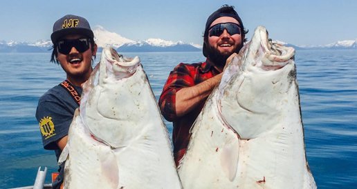 Two guides holding large halibut