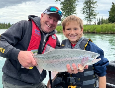 Jimmie and young boy holding a rainbow trout