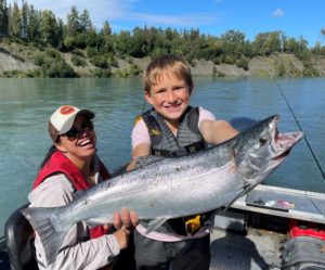 Young boy and Rosy holding a silver salmon