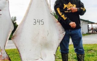 John Collis standing next to huge halibut