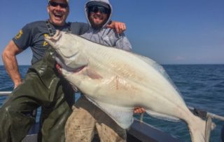 Guest and guide holding a large halibut