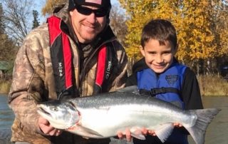 Man and young boy holding a salmon