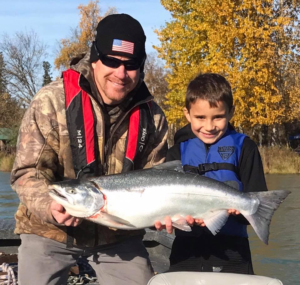 Man and young boy holding a salmon