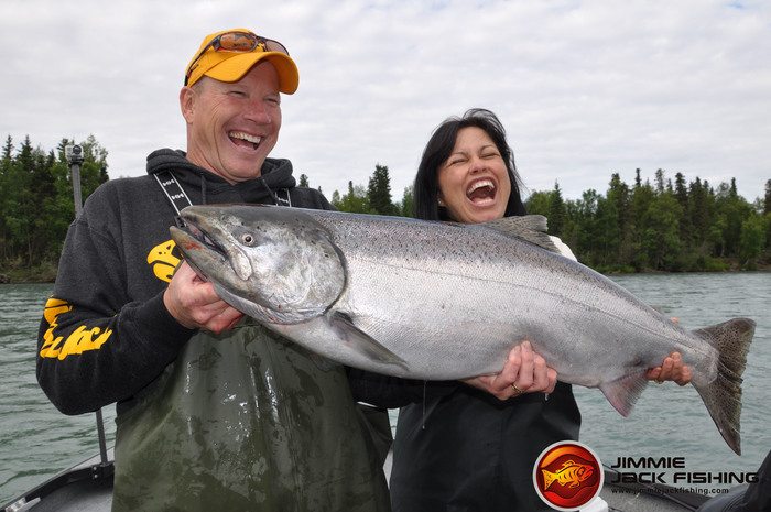 man and woman holding a large salmon