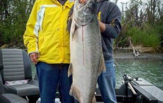 Guide and guest holding a huge salmon