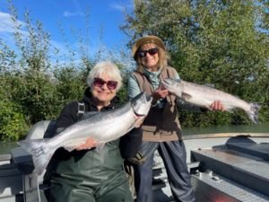 Two women holding salmon