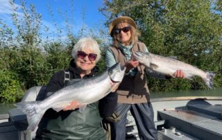 Two women holding salmon