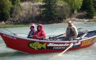 Guests and guide on river fishing boat