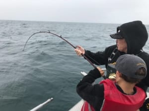 adult and young person open sea fishing