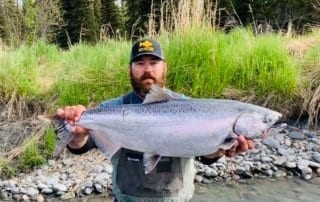 An avid angler shows off a king salmon on the banks of the Kasilof River