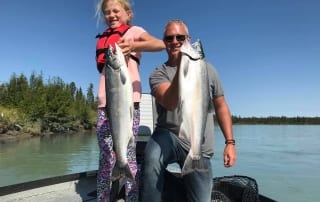 Dad and daughter holding large fish.