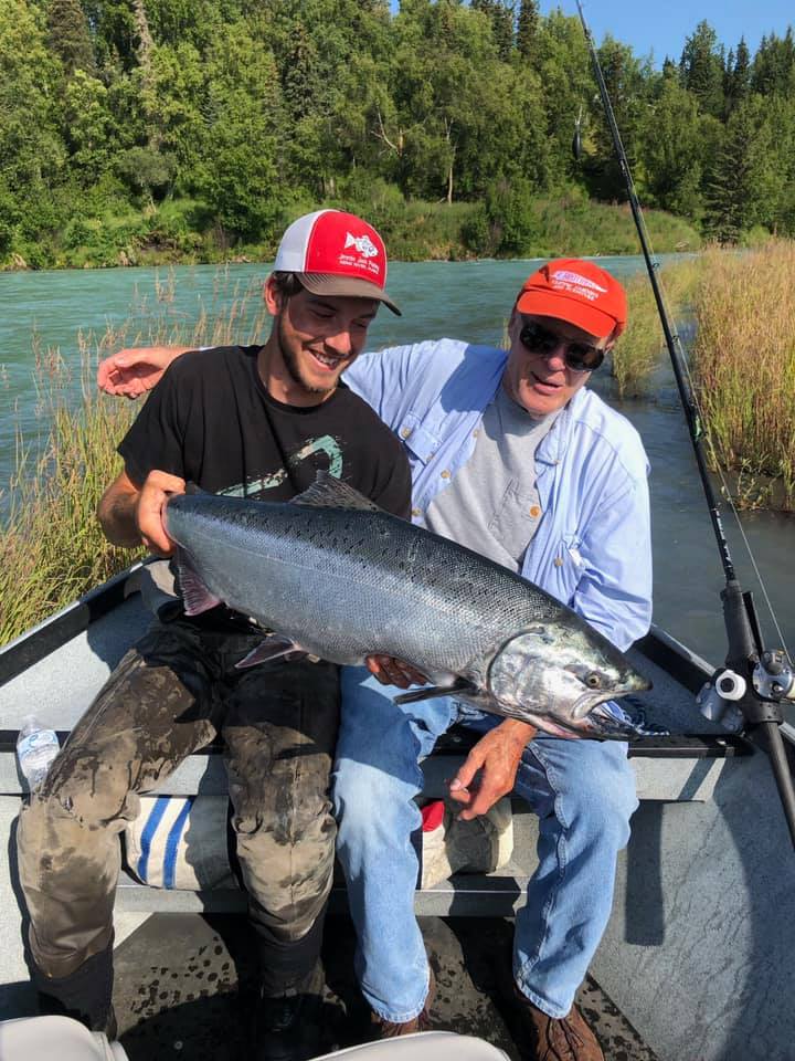Two guests holding silver salmon.