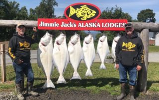 Men standing with hanging fish.