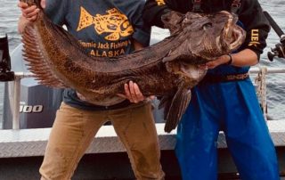 two men holding a lingcod