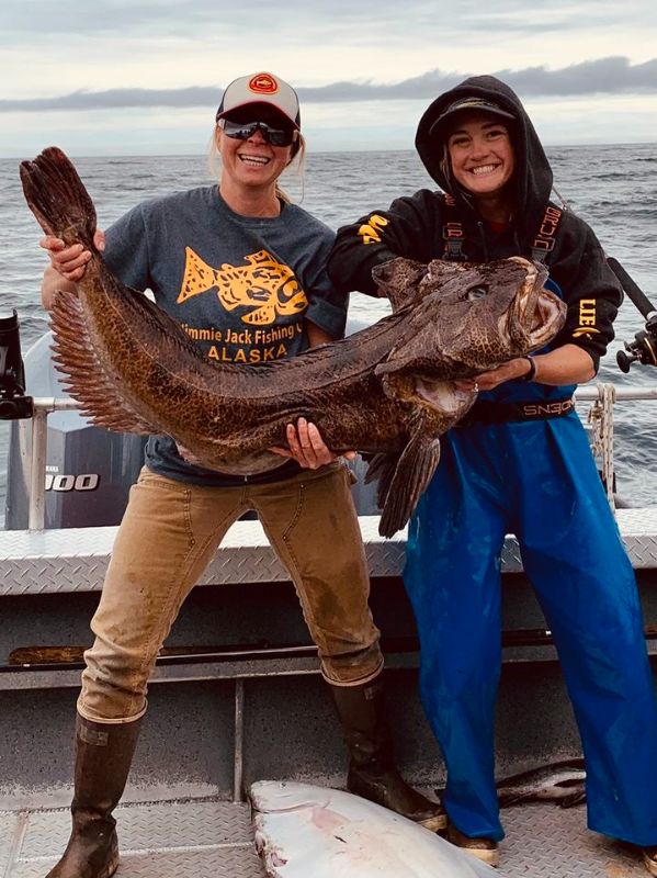 two men holding a lingcod