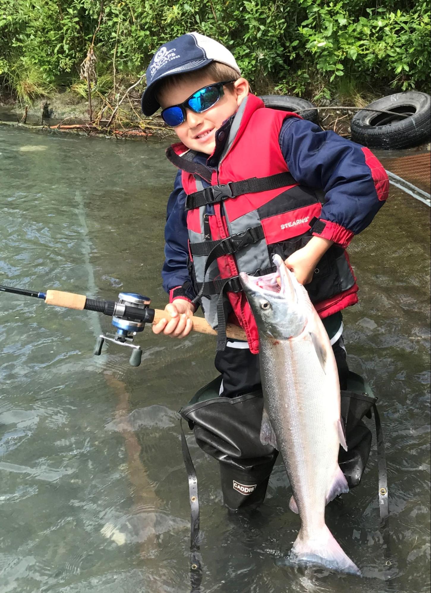 A young angler enjoys a day of Kenai River fishing for sockeye salmon.