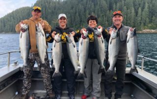 Kenai Fishing Lodges: A group of four anglers each holding two large Kenai River salmon.