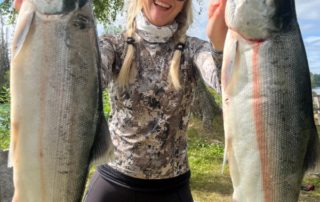 Alaska Fishing Vacations: A woman holds two large salmon she caught on the Kenai Peninsula with Jimmie Jack.