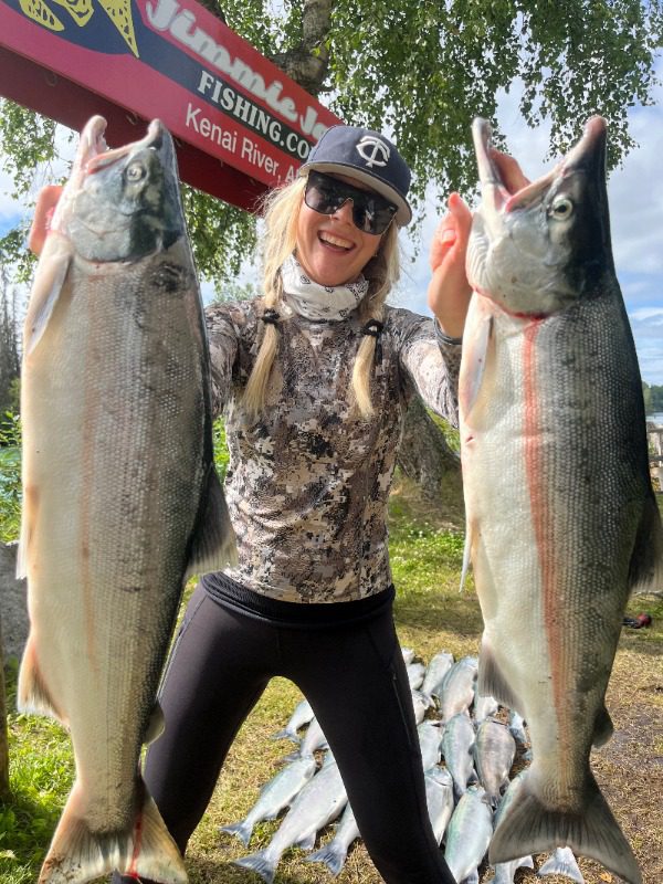 Alaska Fishing Vacations: A woman holds two large salmon she caught on the Kenai Peninsula with Jimmie Jack.