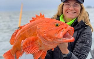 Yelloweye Rockfish: A happy angler holds a large yelloweye while smiling.