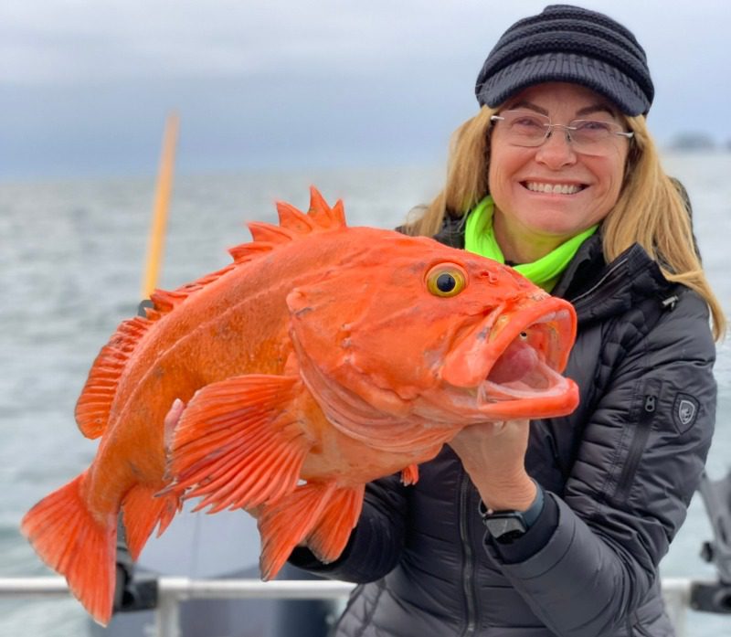 Yelloweye Rockfish: A happy angler holds a large yelloweye while smiling.